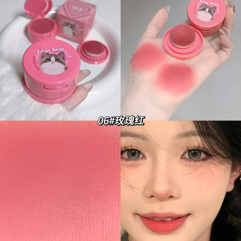 Pink cosmetic blush with a cat design, applied to skin, and on a face labled gege bear on the product and showing pigmentation on the cheek