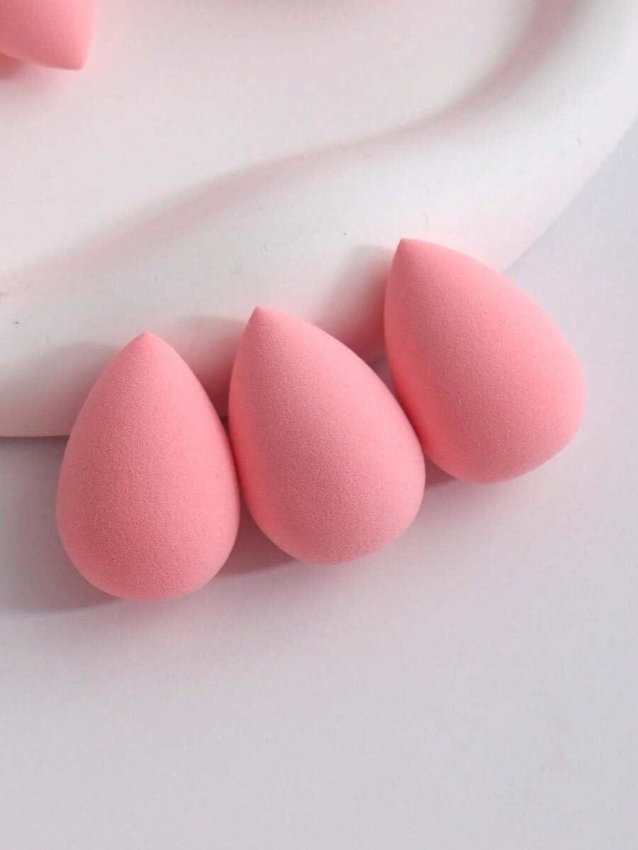Three pink makeup sponges on a light pink background