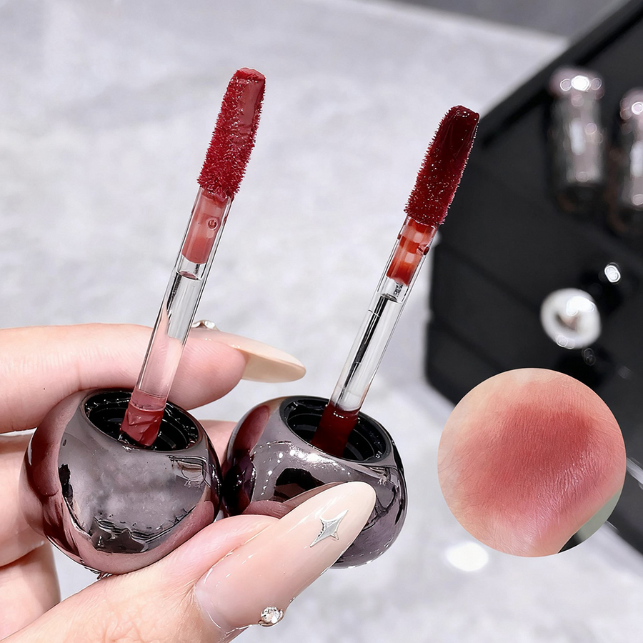 Two lip gloss applicators with a close-up of a lip swatch on a neutral background