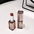 Two lip products on a white surface  in the background