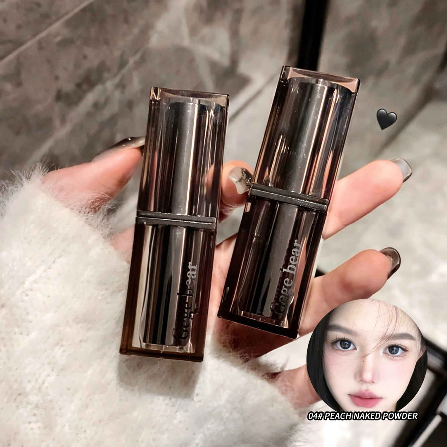 Two makeup products held by a hand with a blurred background