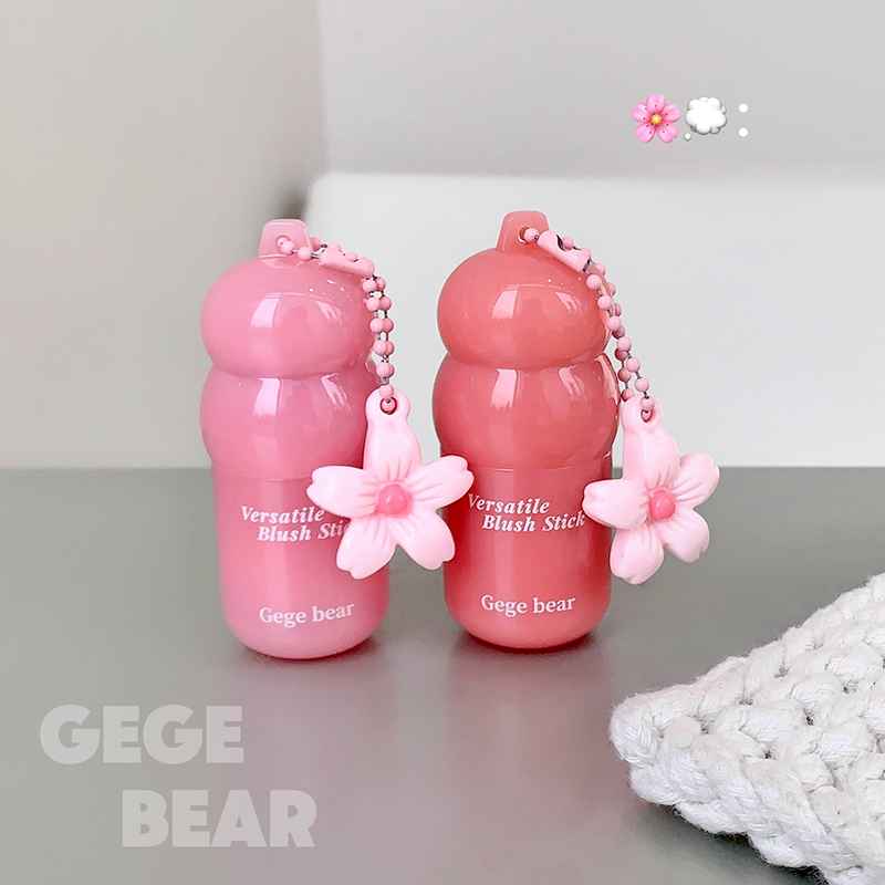 Two pink blush sticks with floral designs on a gray surface, branded 'Gege Bear'.