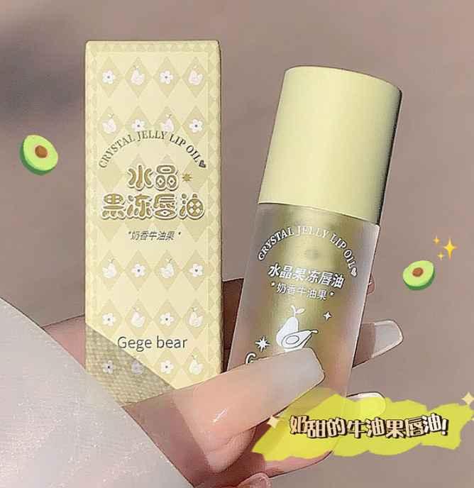 Crystal jelly lip oil with packaging held by a hand, featuring Gege bear branding with avocado flavours