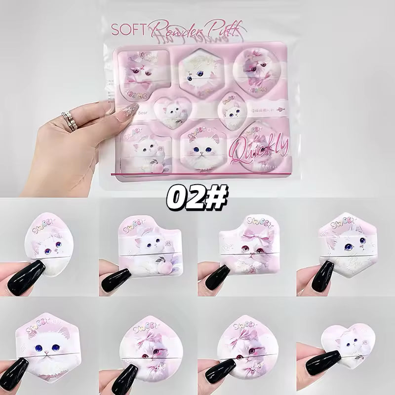 Set of soft powder puffs with cat designs in a clear packaging, held by a hand beauty blender packet held on a pack against white backgrond 