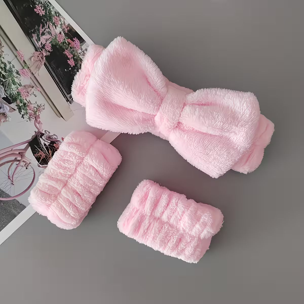 set of headband and wristbands in baby pink color on a grey background 