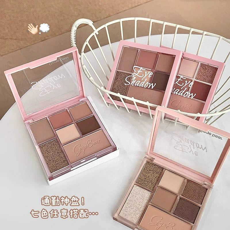 Makeup eyeshadow palettes with pink cases on a white surface