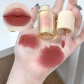 Hand holding a lip gloss with swatches on the skin and close-up of lips.