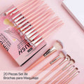 Set of makeup brushes with a pink and gold design on a matching pink background.