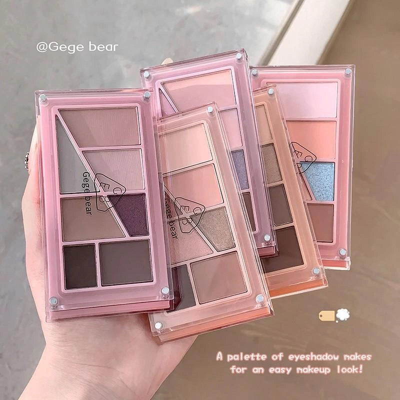 Set of eyeshadow palettes with a multicolors case held by a hand.
