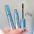 black mascara with open cap, held by a hand against a neutral background in blue japanese packaging 