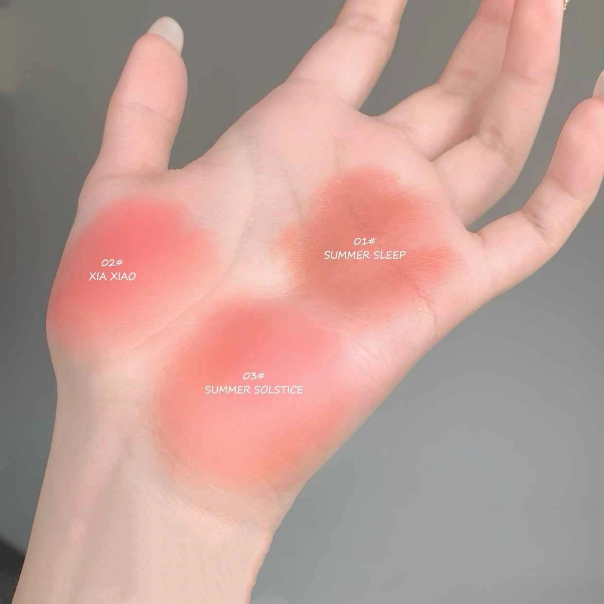 Hand with red patches labeled 'XIA XIA', 'SUMMER SLEEP', and 'SUMMER SOLSTICE' on a gray background