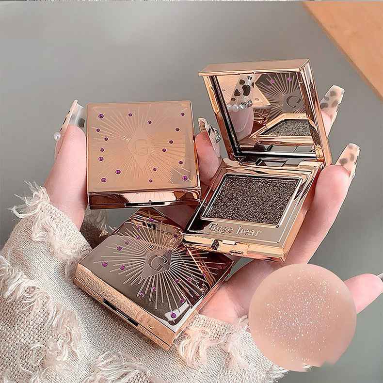 Coffee Brown Eyeshadow palettes with decorative design held by a hand.