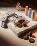 brown beauty blender and plastic tubes on a marble slate 