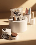 brown beauty blender set in a pouch branded gege bear along with plastic bottles headband makeup cleansing pad eye curler cleansing tube