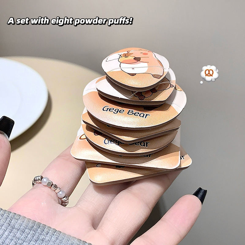 Stack of eight beauty blender with 'Gege Bear' branding held by a hand.