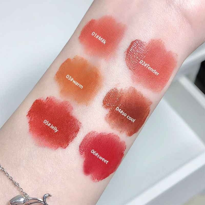 Lipstick swatches on a person's arm with labels