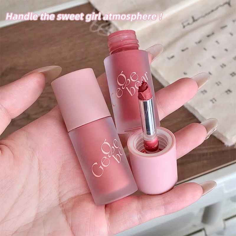 Two matte cream blushes with gege Bear  branding held in a hand against a blurred background.