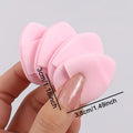 baby pink beauty blender pack of 4 held in between fingers in a white background and showing dimesnion of the puff 