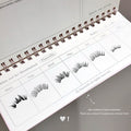 Spiral-bound planner with false eyelashes displayed on each page