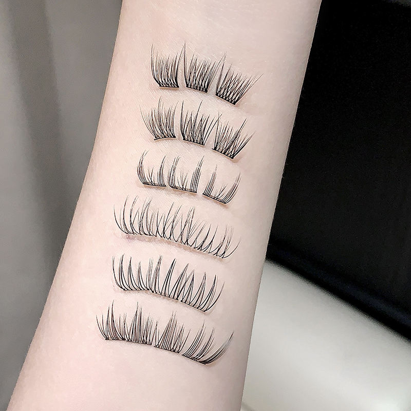 Set of false eyelashes displayed on a person's arm against a neutral background