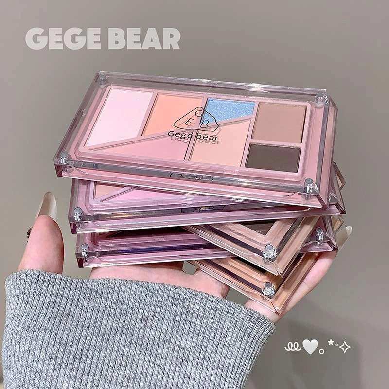 best makeup palette with visible brand name gege bear printed on the top held by a hand, close-up of eye with product application.
