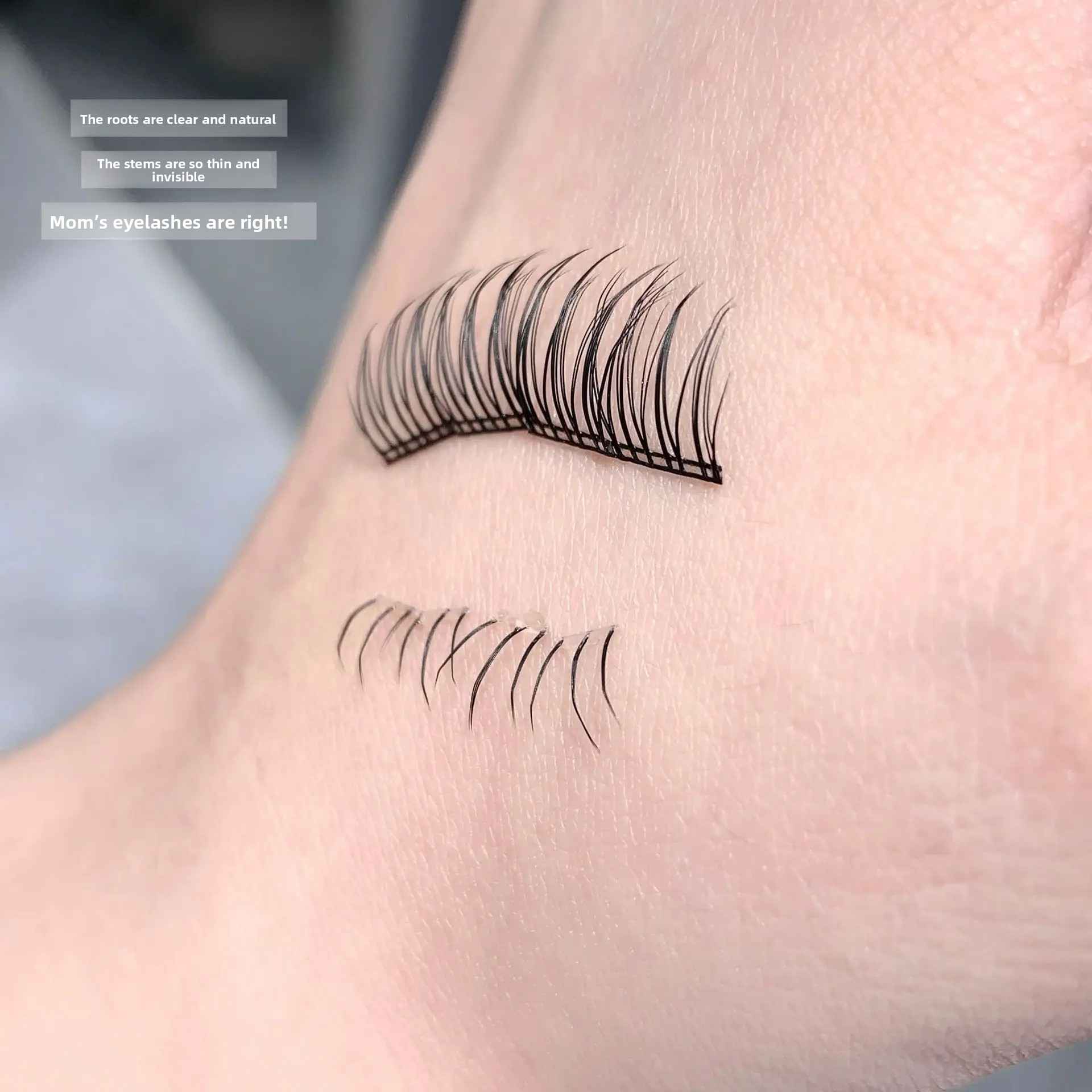 False eyelashes applied to a person's hand with text on a blurred background