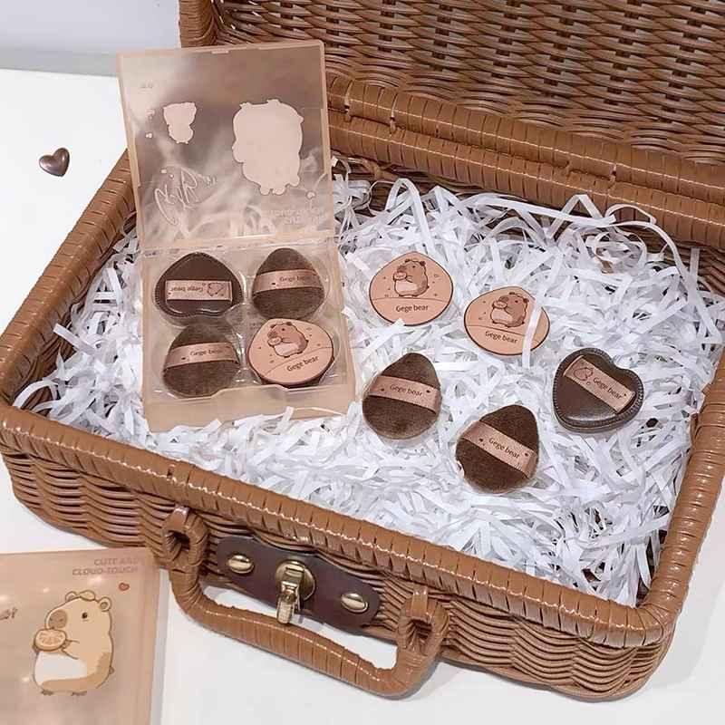 Set of small round makeup blenders in brown color in a wicker basket.