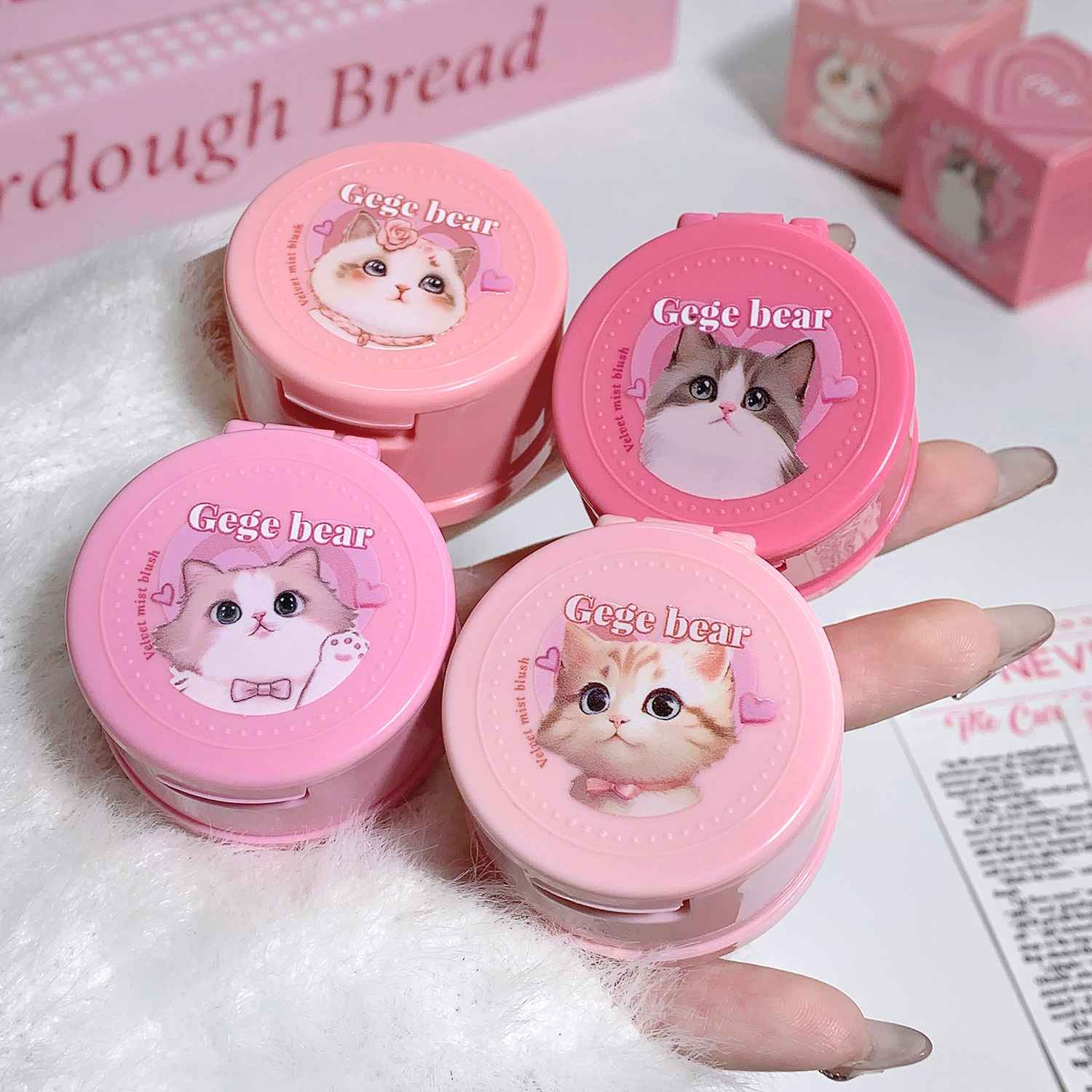 Pink shade powder blushes with cat illustrations labeled 'Gee bear' on a white surface.