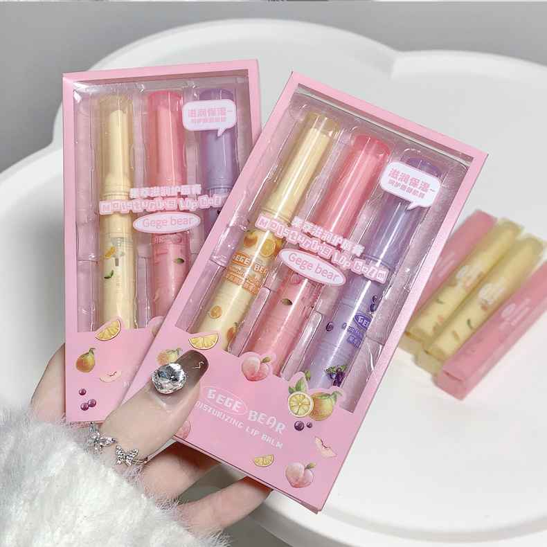 Two pink boxes containing lip lipstick with a hand holding one of them.
