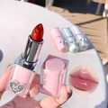 Lipstick with pink case held by a hand, blurred background