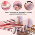 Set of makeup brushes with synthetic bristles on a textured surface.