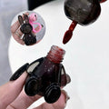 rabbit lip gloss bottle with a brush being used to apply lip gloss close-up view.