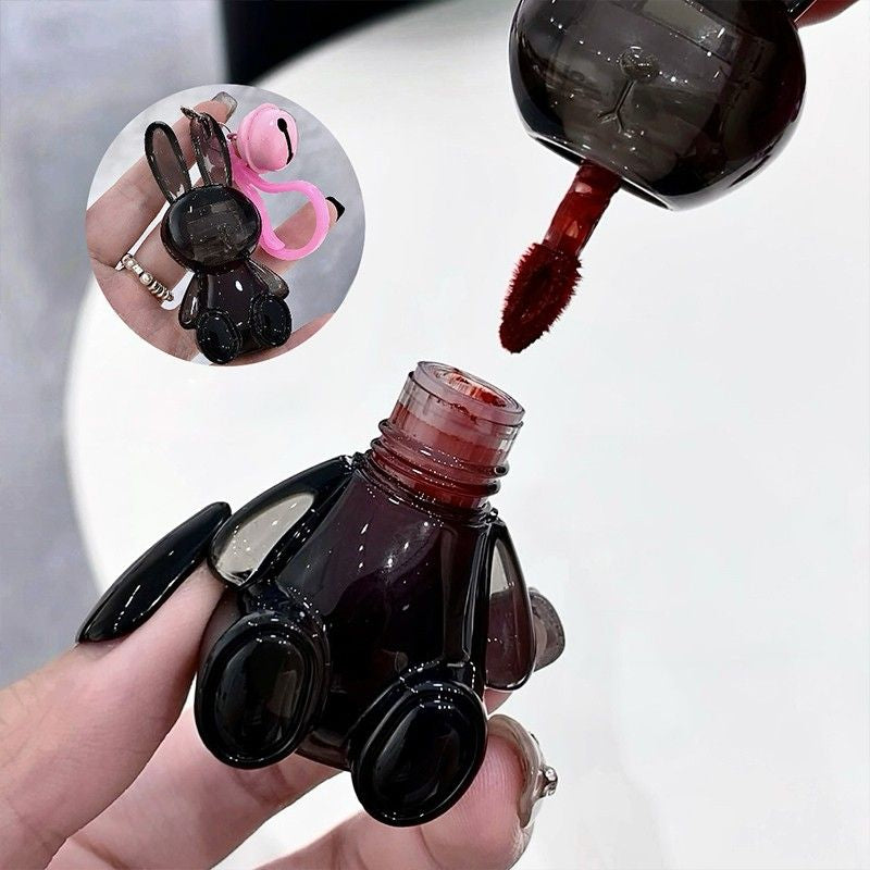 rabbit lip gloss bottle with a brush being used to apply lip gloss close-up view.