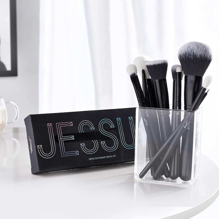 Set of makeup brushes in a clear holder with a black box labeled 'JESSUP' on a white surface.