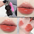Lip gloss with a black bear holder, applied on lips and swatched on skin.