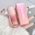 Pink lip gloss with 'Gege bear' branding held by a hand on a white surface.