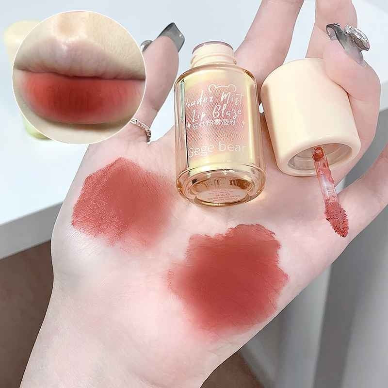 Lip gloss bottle with swatches on a hand, featuring 'gege bear' brand.