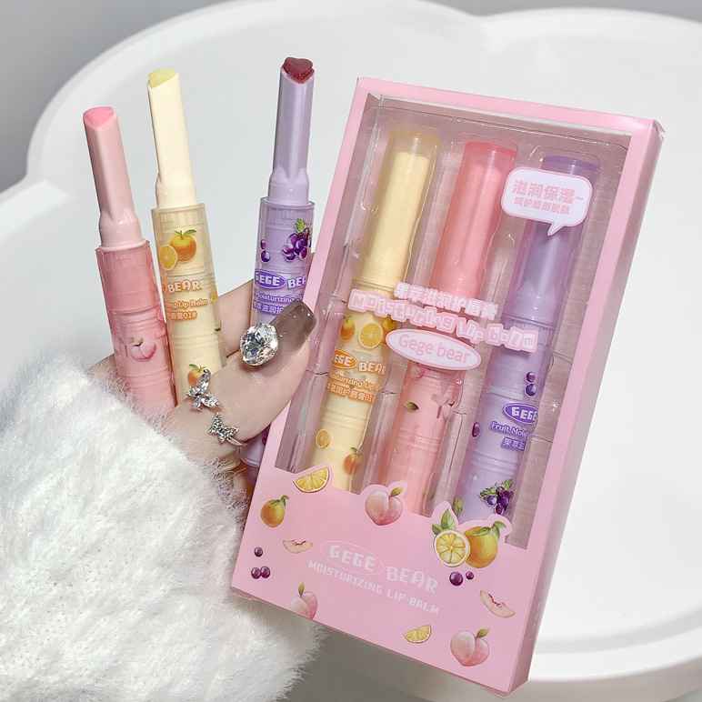Set of colorful lip balms with a pink box on a white background