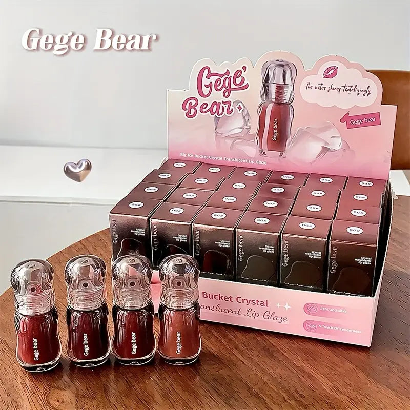 Gege Bear lip gloss display with lip glosses and packaging on a wooden surface.