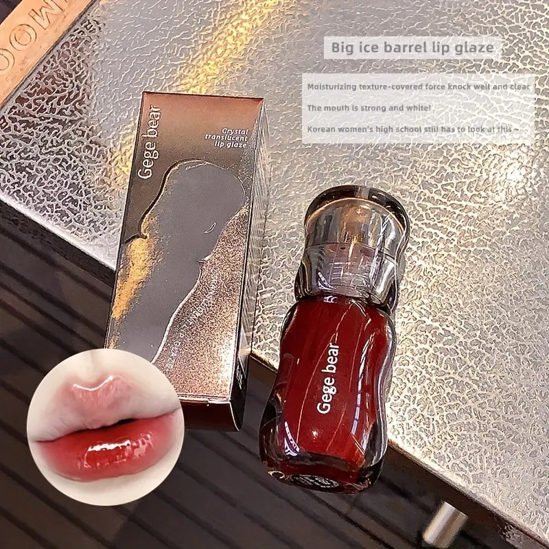 Red lip gloss with packaging on a textured surface