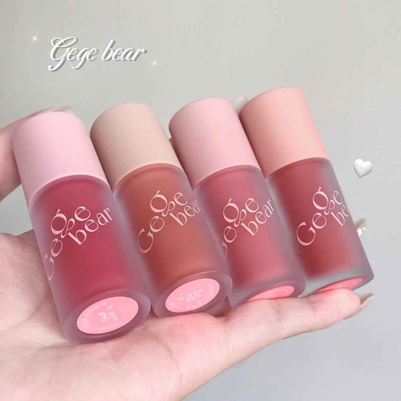 Four lip and cheek blushes from 'Gege bear' held in a hand against a light gray background.