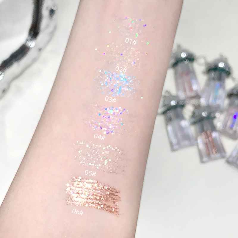 liquid shimmer eyeshadow swatches shown on a arm of a lady in the background lies more eyeshadows in a blurry focus 