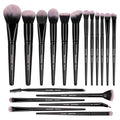 Set of makeup brushes with black handles and pink bristles on a white background