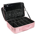 Pink makeup case with black interior compartments on a white background
