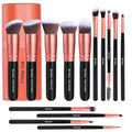 Set of makeup brushes with rose gold and black handles, including a cylindrical packaging container, on a white background.