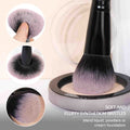 Makeup brush with soft and fluffy synthetic bristles being used to blend foundation.