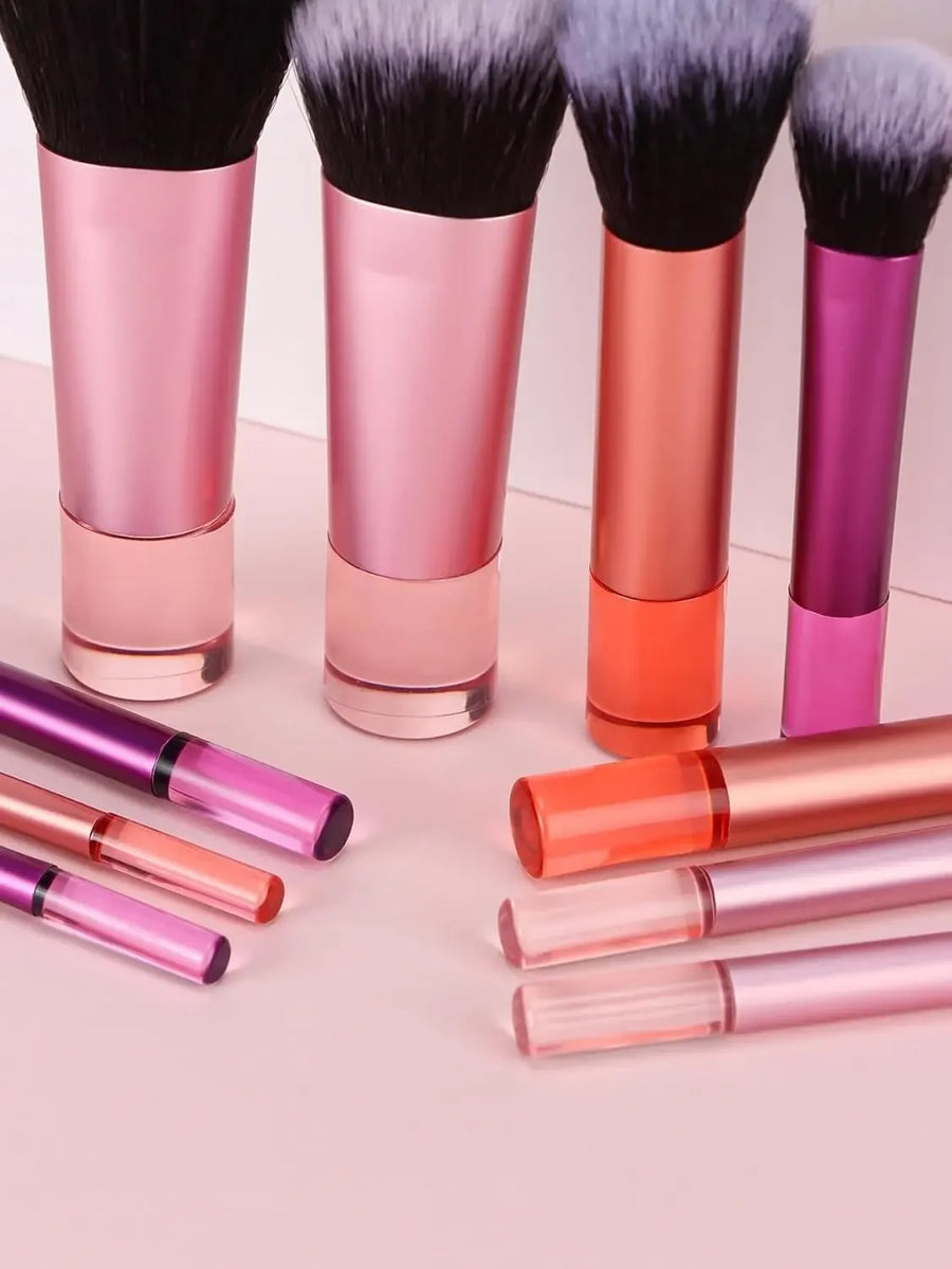Makeup brushes with pink and orange handles on a light pink background