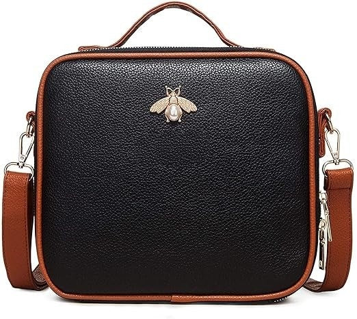 Black leather handbag with brown accents and a bee emblem on a white background