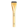 Gold makeup brush with black bristles on a white background