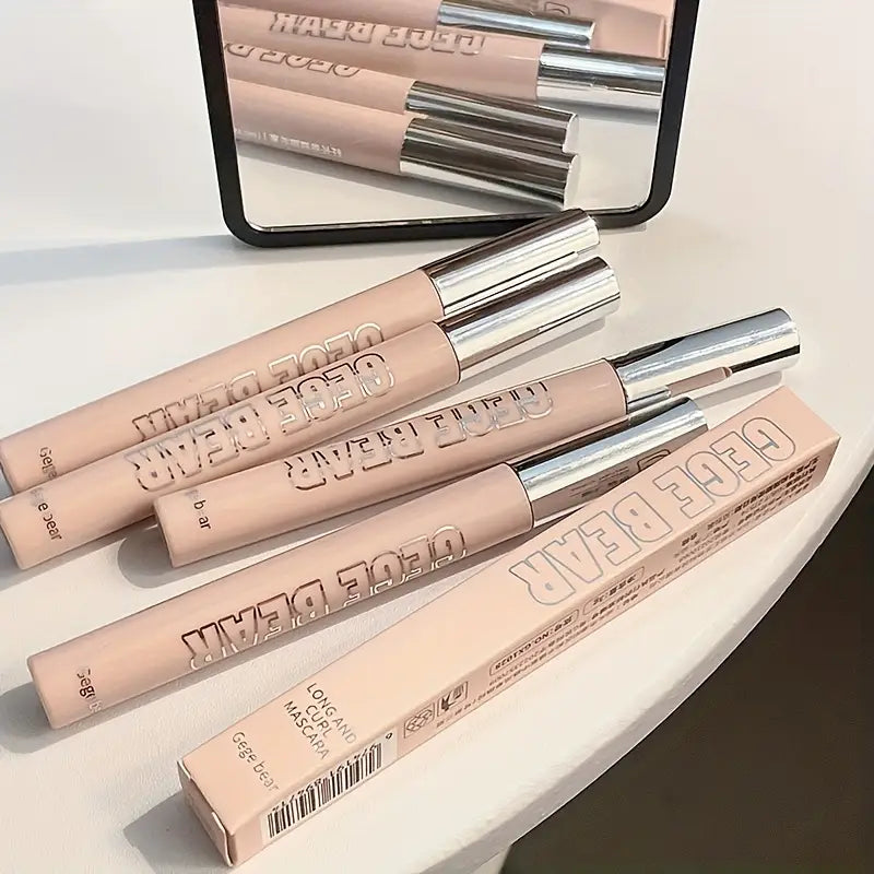 Four gege bear mascara with their packaging on a light surface